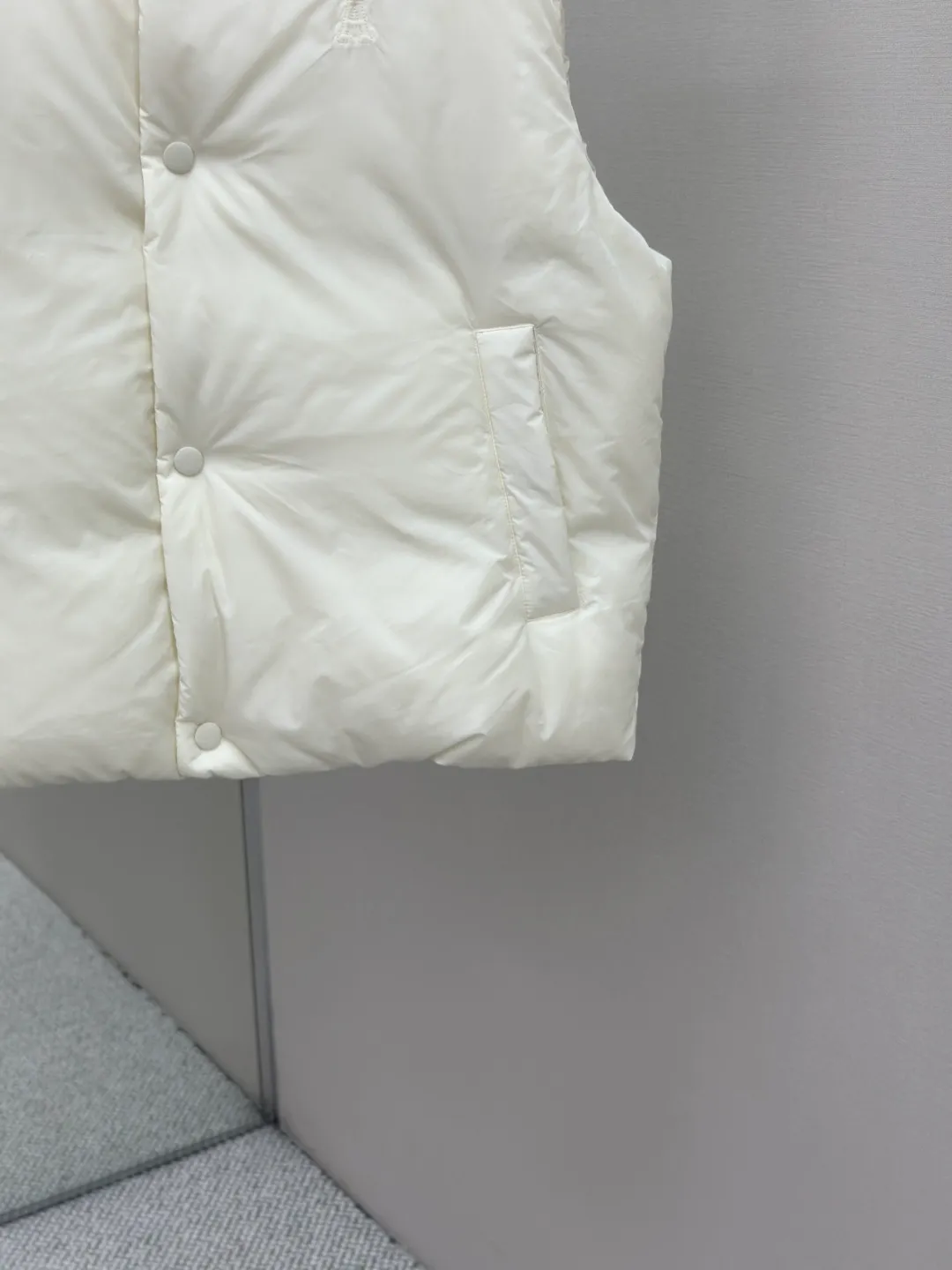 P810 AMIPARIS love padded embroidered down vest Fabric selection: Taffeta fabric woven from 100% polyester fiber. It adopts warp and weft plain weave and is woven very tightly, making the surface of the fabric extremely smooth and flat, with a "skinny" and stiffness that is not easy to collapse. When rubbed or moved around, it will make a unique, crisp "rustling" sound. At the same time, it has a delicate plain texture and a soft, elegant silky luster. This kind of luster is not as dazzling as satin, but more restrained and advanced.  Lining selection: Use 100% nylon to create the lining. The high-density and tight weaving process prevents tiny lint from getting out of the gaps in the fabric. The smooth surface improves the putting on and taking off experience, and the excellent wear and tear resistance ensures damage caused by frequent use, while the light and soft texture does not affect the overall weight.  Technology: The fabric and padding material are tightly fixed on the frame of the embroidery machine. The embroidery machine uses sparse stitches along the padding layer to outline the filling area of the pattern, and then runs the overlay layer's padding, using dense stitches to perfectly cover the foam padding layer, thus forming a slightly raised love embroidery, which feels soft and full, enhancing recognition while maintaining a low profile. High-quality filling: It uses 90 white duck down with a weight of 160g to ensure excellent thermal insulation performance. After strict screening and processing, the velvet is not easy to get drilled, ensuring durability.  Accessories: One-to-one customized three-standard, one-to-one customized hem elastic buckle, one-to-one customized snap button SIZE: XS S M L